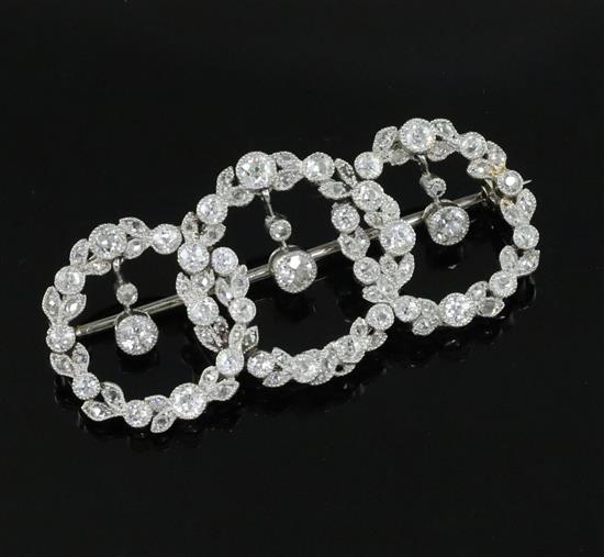 A 1920s white gold and diamond set interlocking triple circle openwork drop brooch,
